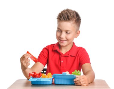 Masasında beyaz arka planda beslenme çantası olan öğrenci.