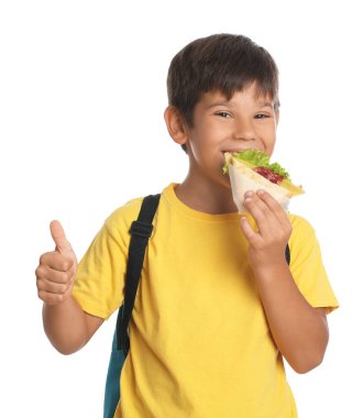 Öğrenci beyaz arka planda sandviç yiyor.