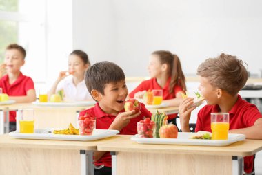 Öğrenciler sınıfta sağlıklı öğle yemeği yiyor.