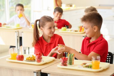 Öğrenciler sınıfta sağlıklı öğle yemeği yiyor.