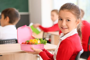 Sınıfta beslenme çantası olan kız öğrenci.