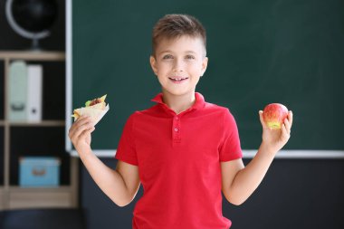 Okulun bulanık geçmişine karşı elma ve sandviçli öğrenci.