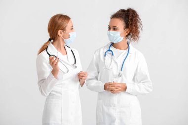 Hafif arka planda tıbbi maske takan kadın doktorların portresi