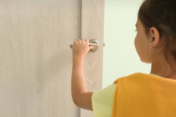 Little girl opening door, closeup