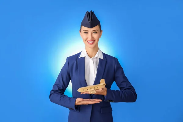 Schöne Stewardess Mit Holzflugzeug Auf Farbigem Hintergrund — Stockfoto