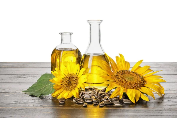 Ölflaschen Samen Und Sonnenblumen Auf Dem Tisch Vor Weißem Hintergrund — Stockfoto