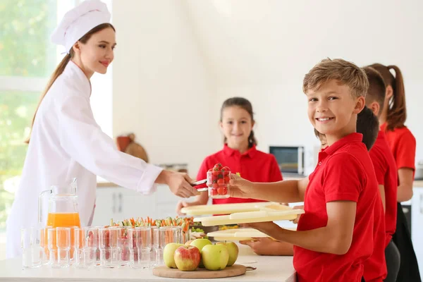 Pupils receiving lunch in school canteen