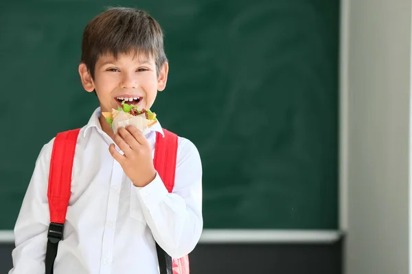Schuljunge Isst Sandwich Vor Verschwommenem Hintergrund Der Schule — Stockfoto