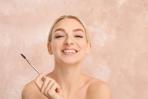 Mujer Joven Corrigiendo Sus Cejas Sobre Fondo Color — Foto de Stock