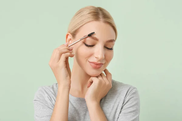 Jonge Vrouw Corrigeren Haar Wenkbrauwen Kleur Achtergrond — Stockfoto