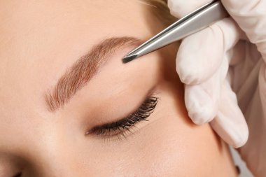 Kaş düzeltme prosedüründen geçen genç bir kadın, yakın plan.