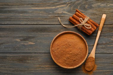 Tarçın çubukları ve tahta zemin üzerindeki toz.