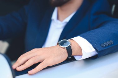 Kol saati gibi şık arabası olan yakışıklı bir iş adamı.