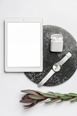 Kol saati, tablet bilgisayar ve hafif arkaplanda kulaklıklar