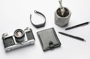 Beyaz arkaplanda fitness takip cihazı ve fotoğraf makinesi ile şık kompozisyon