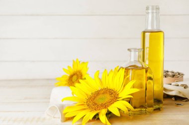 Ahşap arka planda yağ ve ayçiçeği şişeleri