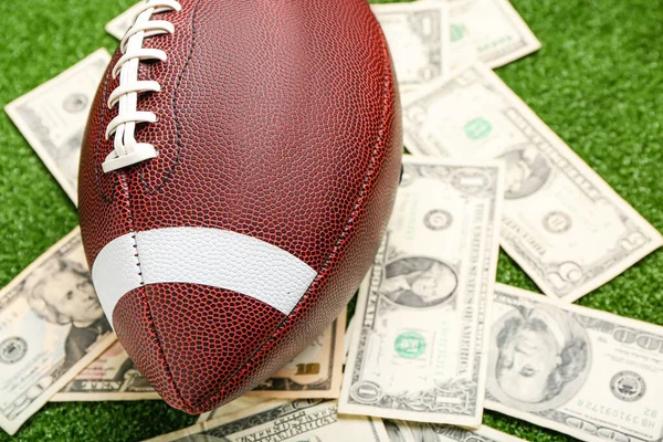 色の背景にお金とラグビーボール クローズアップ スポーツベットの概念 — ストック写真