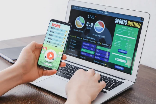 Smartphone com aplicativo de jogo online, notas de dólar e bola de futebol  em um teclado. conceito de apostas. vista do topo.