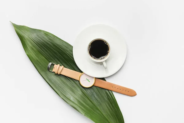 スタイリッシュな腕時計 白を背景にコーヒーと緑の葉のカップ — ストック写真