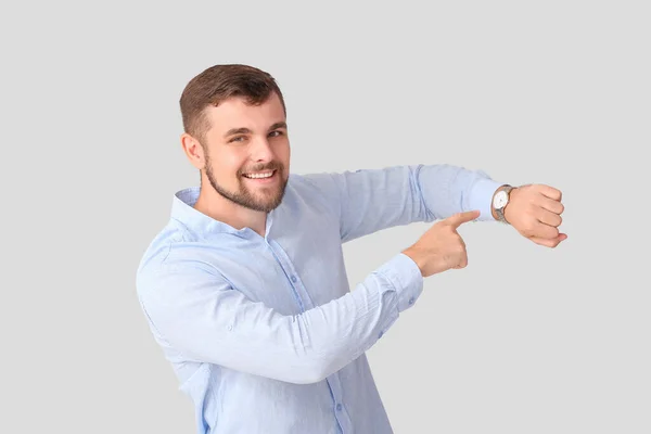 Snygg Man Pekar Armbandsur Ljus Bakgrund — Stockfoto