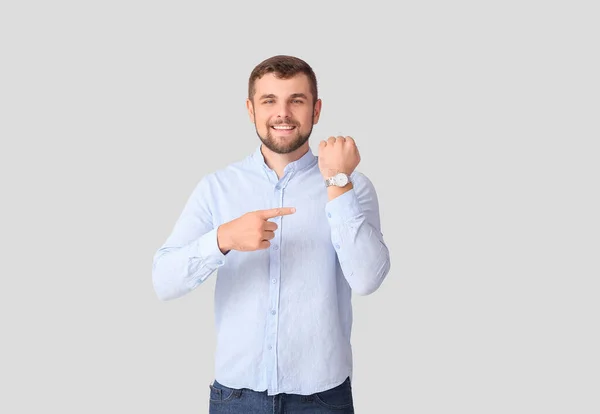 Snygg Man Pekar Armbandsur Ljus Bakgrund — Stockfoto