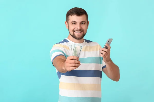 Joven Hombre Con Dinero Teléfono Móvil Fondo Color Concepto Apuesta —  Fotos de Stock