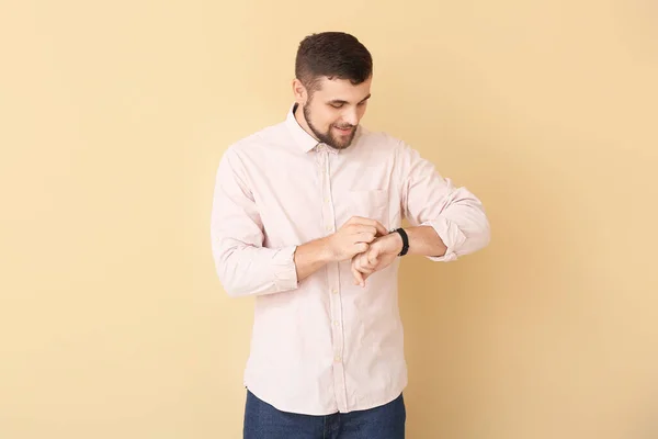 Hombre Guapo Mirando Reloj Pulsera Sobre Fondo Color — Foto de Stock