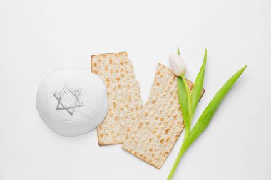 Fısıh bayramı için Yahudi ekmek matzası, beyaz arka planda kep ve çiçek