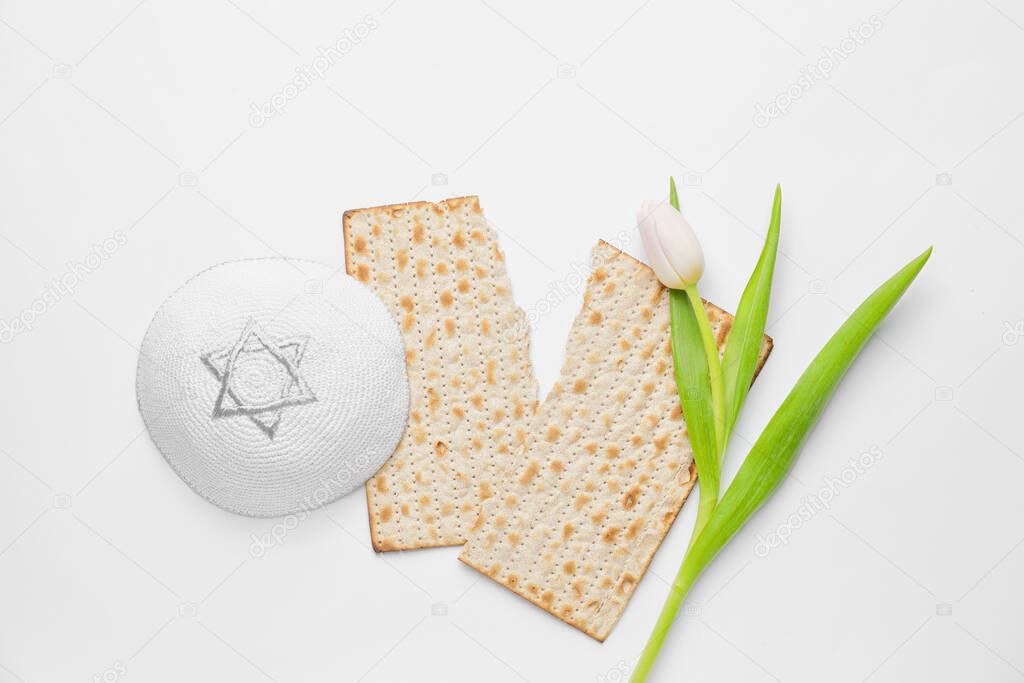 Jewish flatbread matza for Passover, cap and flower on white background