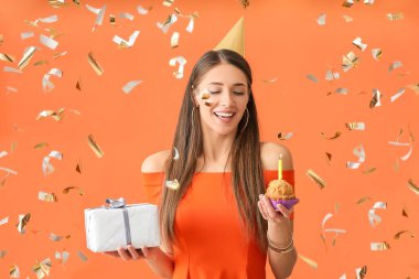 Genç bir kadın doğum gününü renk arka planında kutluyor