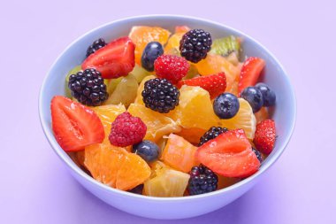 Renkli arkaplanda meyve salatası ile kase