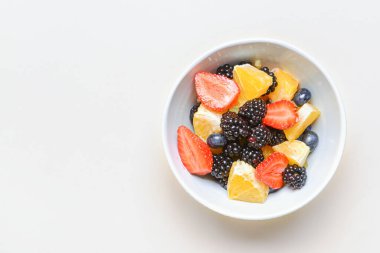 Beyaz arka planda meyve salatası ile kase