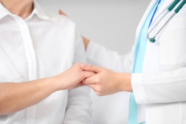 Klinikte kimyasal terapi gören doktor ve olgun kadınların elleri.