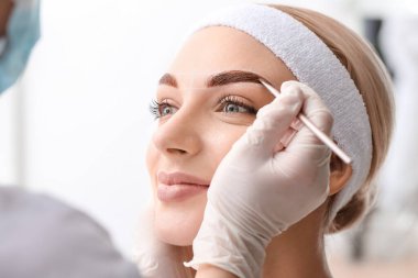 Güzellik salonunda kaş düzeltme ameliyatı olan genç bir kadın.