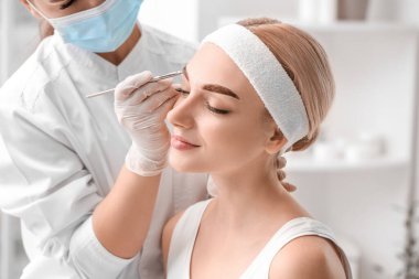 Güzellik salonunda kaş düzeltme ameliyatı olan genç bir kadın.