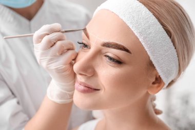 Güzellik salonunda kaş düzeltme ameliyatı olan genç bir kadın.