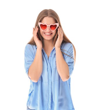 Beyaz arka planda, kalp şeklinde güneş gözlüklü güzel bir genç kadın.