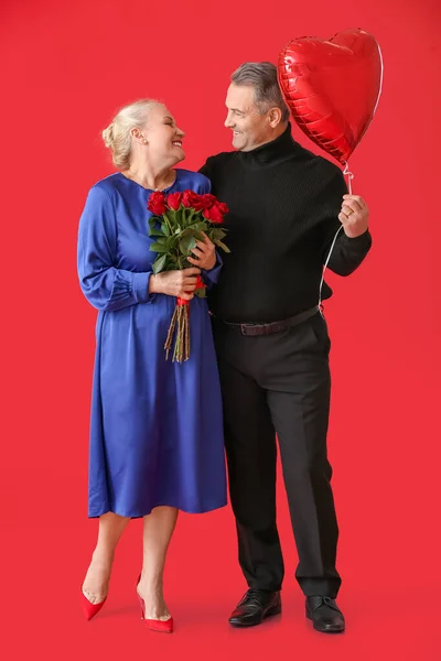 Зрелая Пара Шариком Цветами Цветном Фоне Празднование Дня Святого Валентина — стоковое фото