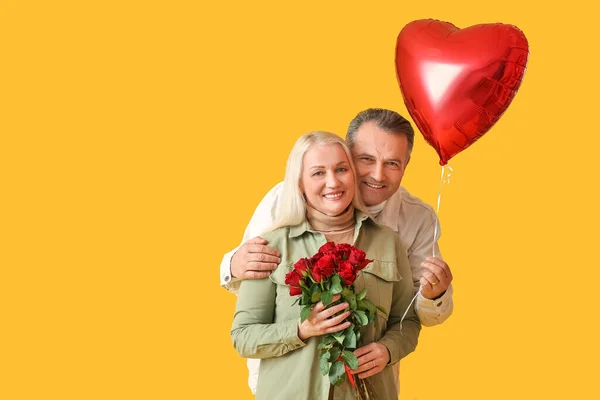 成熟的夫妇与气球和花的颜色背景 情人节庆祝活动 — 图库照片