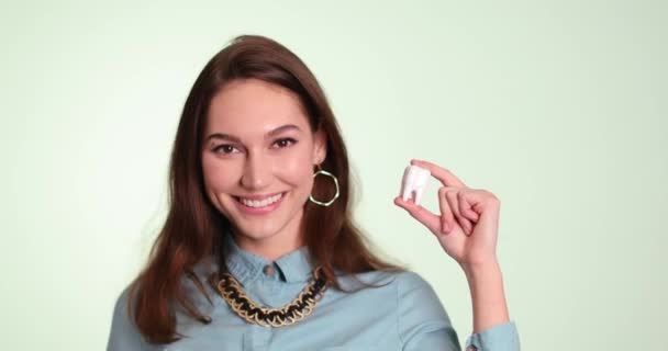 色の背景に美しい笑顔とプラスチック歯を持つ若い女性 — ストック動画