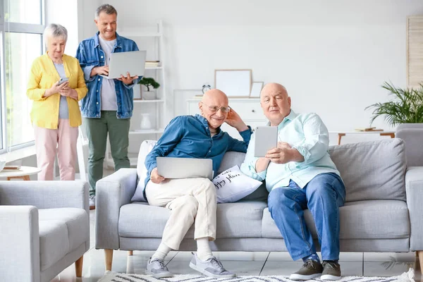 Oudere Mensen Met Verschillende Apparaten Thuis — Stockfoto