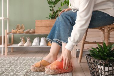 Genç bir kadın evde rahatsız edici ayakkabılar giydiği için acı çekiyor.