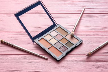 Ahşap masada güzel bir göz falı ve fırça paleti.