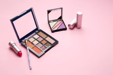 Göz falı paleti, renk arkaplanı üzerinde fırça ve dudak parlatıcısı