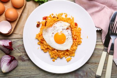 Ahşap zemin üzerinde lezzetli yumurta ve pirinç tabağı.