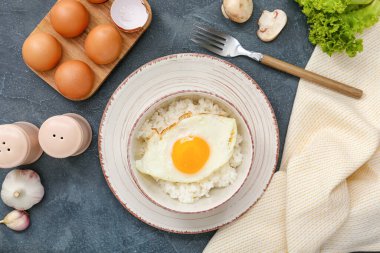 Koyu arkaplanda lezzetli yumurta ve pilav var.