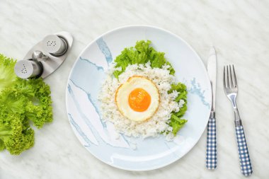 Hafif arka planda lezzetli yumurta ve pilav tabağı.