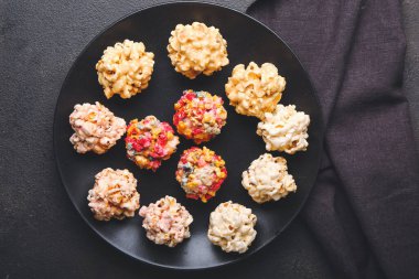 Koyu arkaplanda lezzetli patlamış mısır topları olan bir tabak.