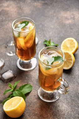 Arkaplanda limon olan bir fincan soğuk siyah çay.