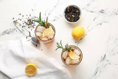 Açık arkaplanda limonlu soğuk siyah çay.